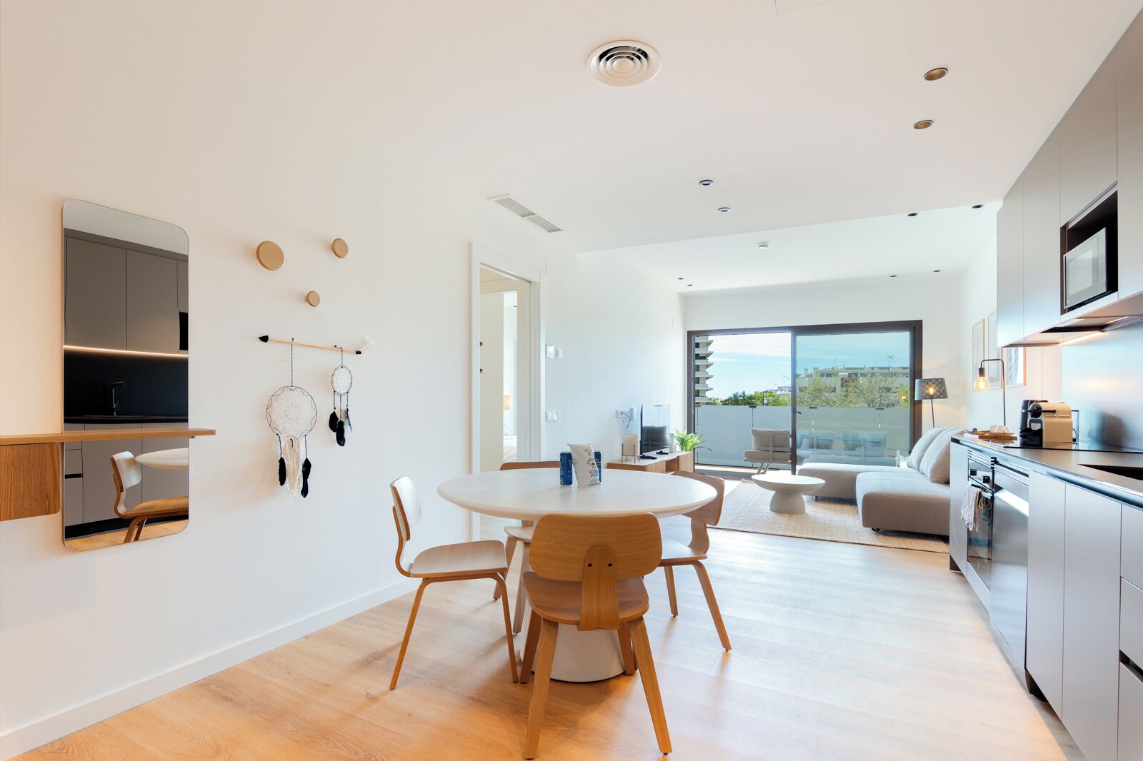 A modern kitchen with a dining area, a TV, and a view of the outdoors.