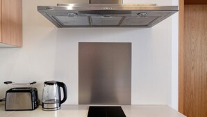 A kitchen with a stainless steel range hood, a toaster, and a coffee maker on the counter. - Apartment 'Fewo Schwan' with Wi-Fi (Malchow)