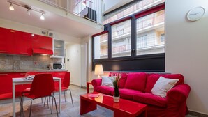 A modern apartment with a red dining area, a red sofa, and a kitchen with red cabinets. - Loft Vermouth by Wonderful Italy (Torino)