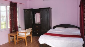 A bedroom with a bed, a wooden chair, a dark wooden wardrobe, and a window with curtains. - Annapurna Himdrishya Pokhara Homestay (Pokhara)