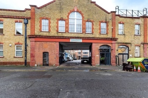 A brick building with a large arched entrance and a sign above the door. - Bright 1 Bedroom Apartment in London (London)