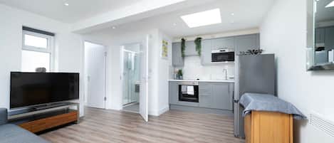 A modern apartment with a living room, kitchen, and a small dining area.