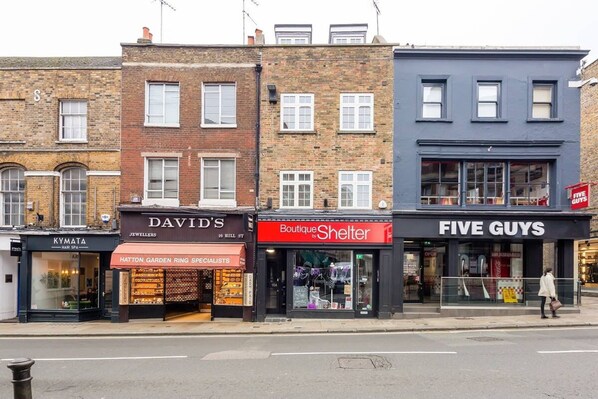 Une vue de la rue avec la bijouterie de David, une boutique de la marque Shelter et le restaurant Five Guys.
