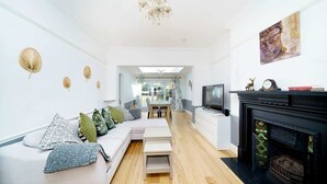 Ein modernes Wohnzimmer mit einer Couch, einem Kamin und einem Fernseher.