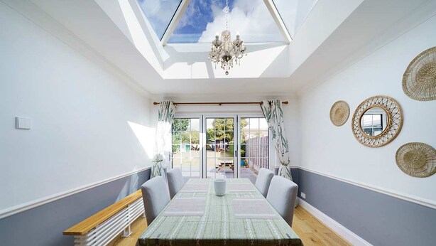 Ein Esszimmer mit Tisch, Stühlen und einer Kronleuchter.