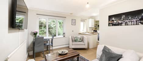 A modern living room with a sofa, coffee table, and a dining area with a chair and table.
