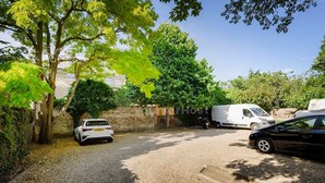 A gravel driveway with parked cars and a white van. - Cozy One-bedroom Flat in Slough (Slough)