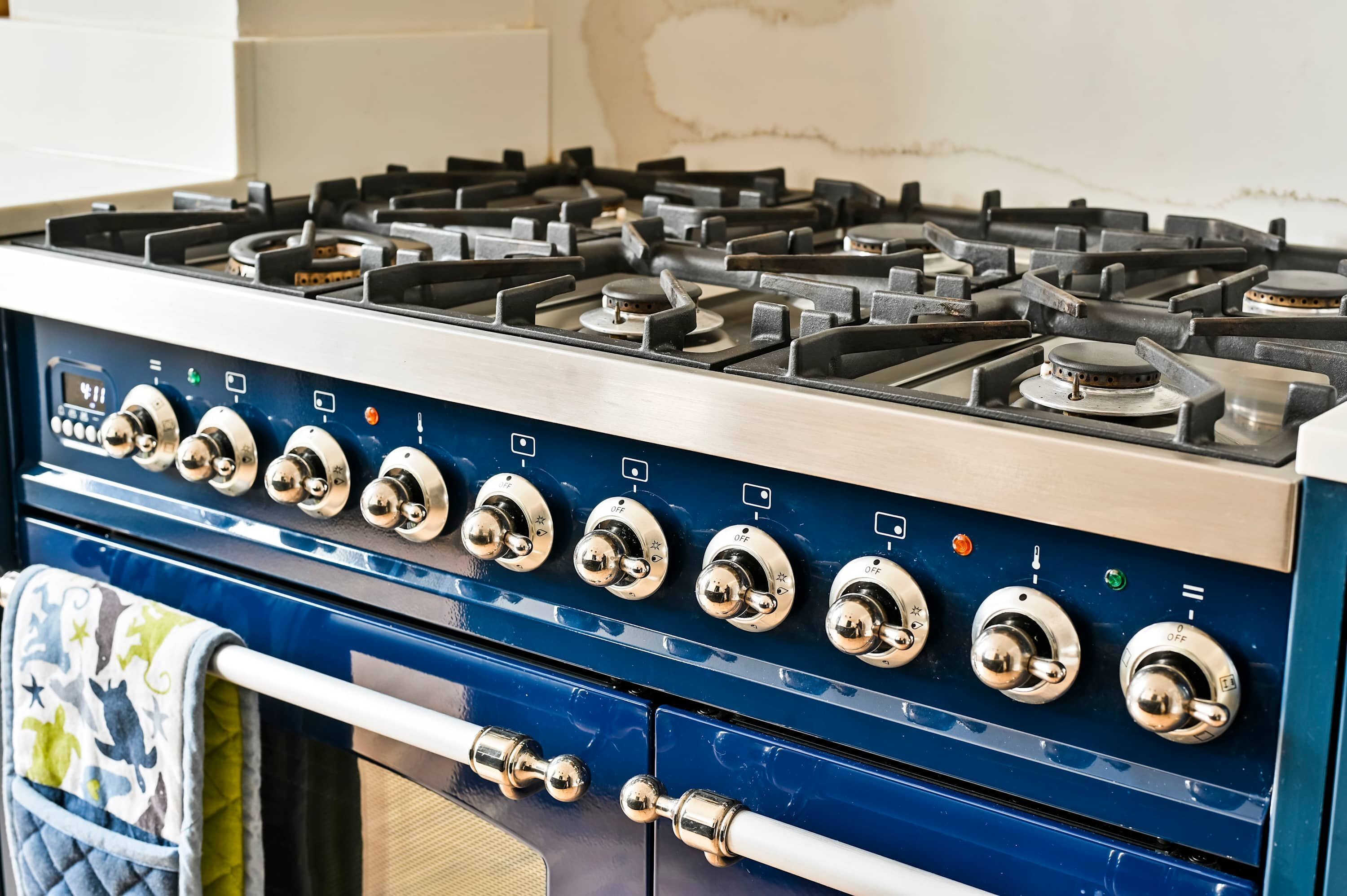 A kitchen with a blue stove and multiple burners.