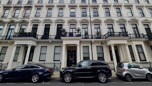 A multi-story building with a symmetrical facade, large windows, and black wrought iron balconies. - Stylish 1 Bed in SW7 With Private Balcony (London)