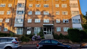 A multi-story brick building with a sign reading "Stratton Court." - Charming Flat Near London Attractions (Surbiton)