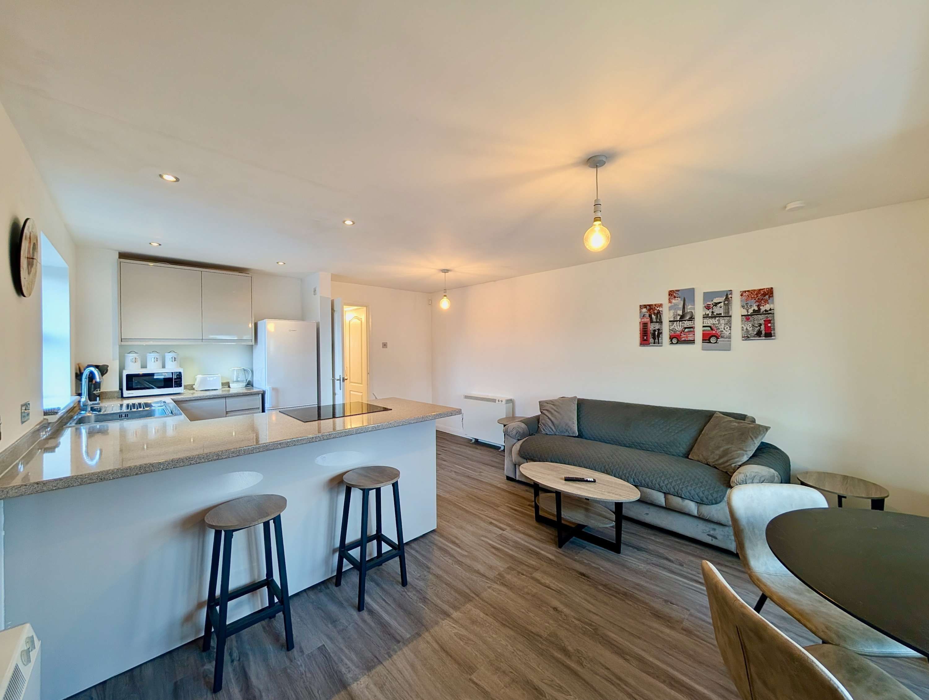 A modern apartment with a kitchen, dining area, and living room.