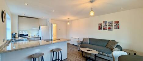 A modern apartment with a kitchen, dining area, and living room.