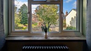 A window with a view of a garden and a brick building. - Charming Flat With Free Parking in Prime Location (Royal Tunbridge Wells)