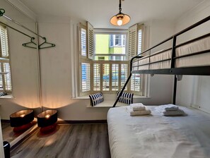 A room with a bunk bed, a window with shutters, a mirror, and a hanging light fixture. - Charming House With Balcony Near Brighton Beach (Brighton)