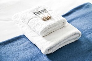 En hög med vita handdukar ligger på ett blått handduk.