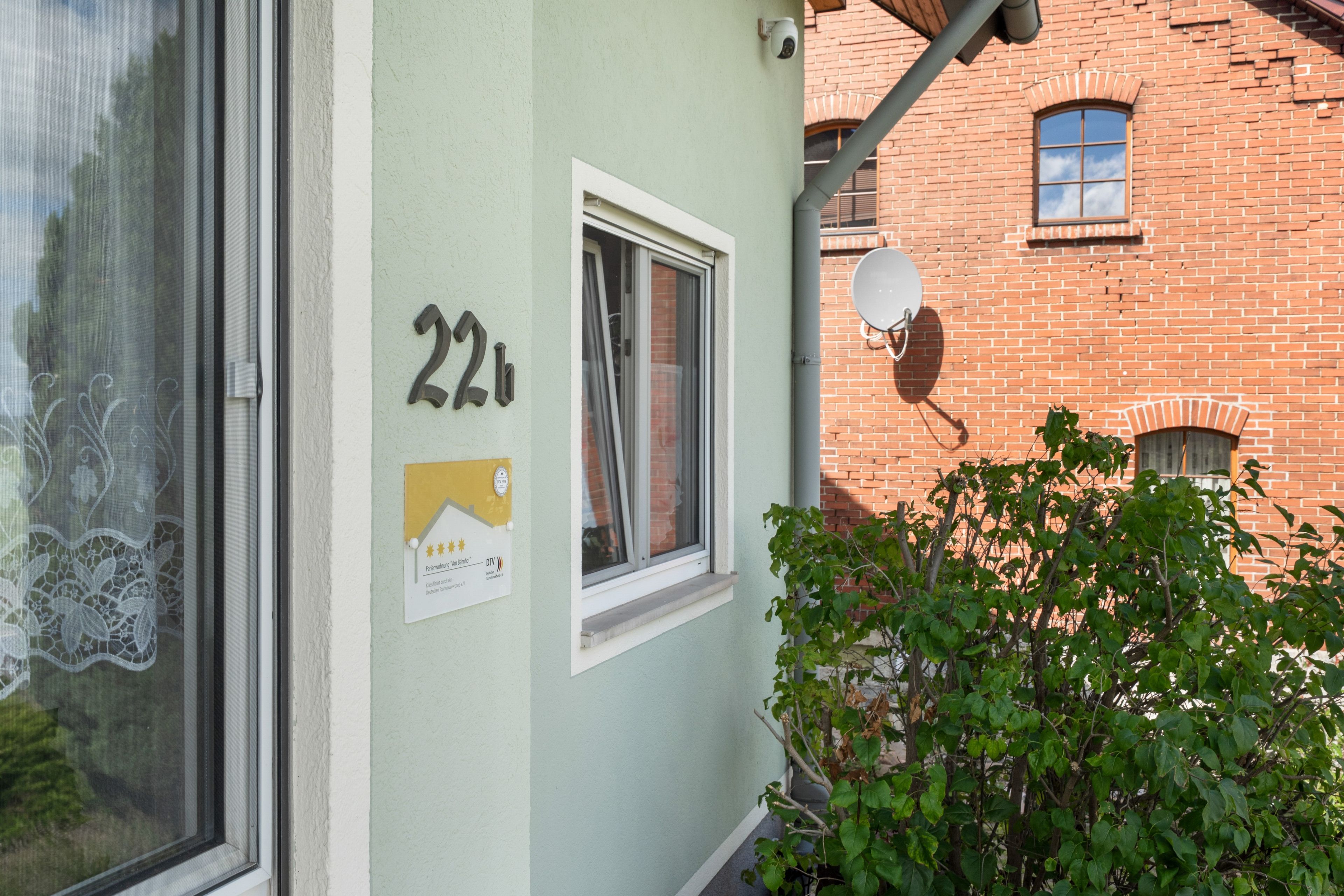A building with a window, a door, and a number '22' on the wall.