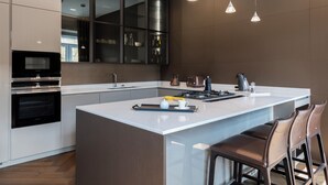 A modern kitchen with a large island, stainless steel appliances, and pendant lighting. - LuxTOPFloor (Valletta)