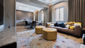 A modern living room with a sofa, ottomans, and a patterned rug. - LuxTOPFloor (Valletta)