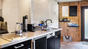 Et moderne køkken med opvaskemaskine, elkedel og kaffemaskine.