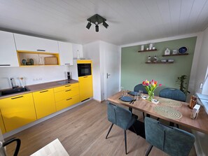 A modern kitchen with yellow cabinets, a wooden countertop, and a built-in oven.