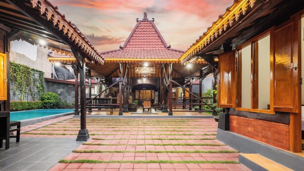 Ein traditionelles Gebäude mit Ziegeldach, Innenhof und Pool.