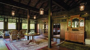 A traditional room with wooden furniture, a round table, and a cabinet.