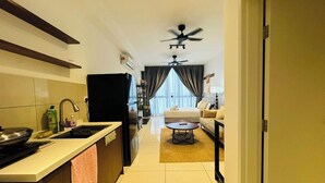 A modern kitchen with a dining area, a ceiling fan, and a view through a window. - Golden Suites At Majestic Residence Klcc (Kuala Lumpur)