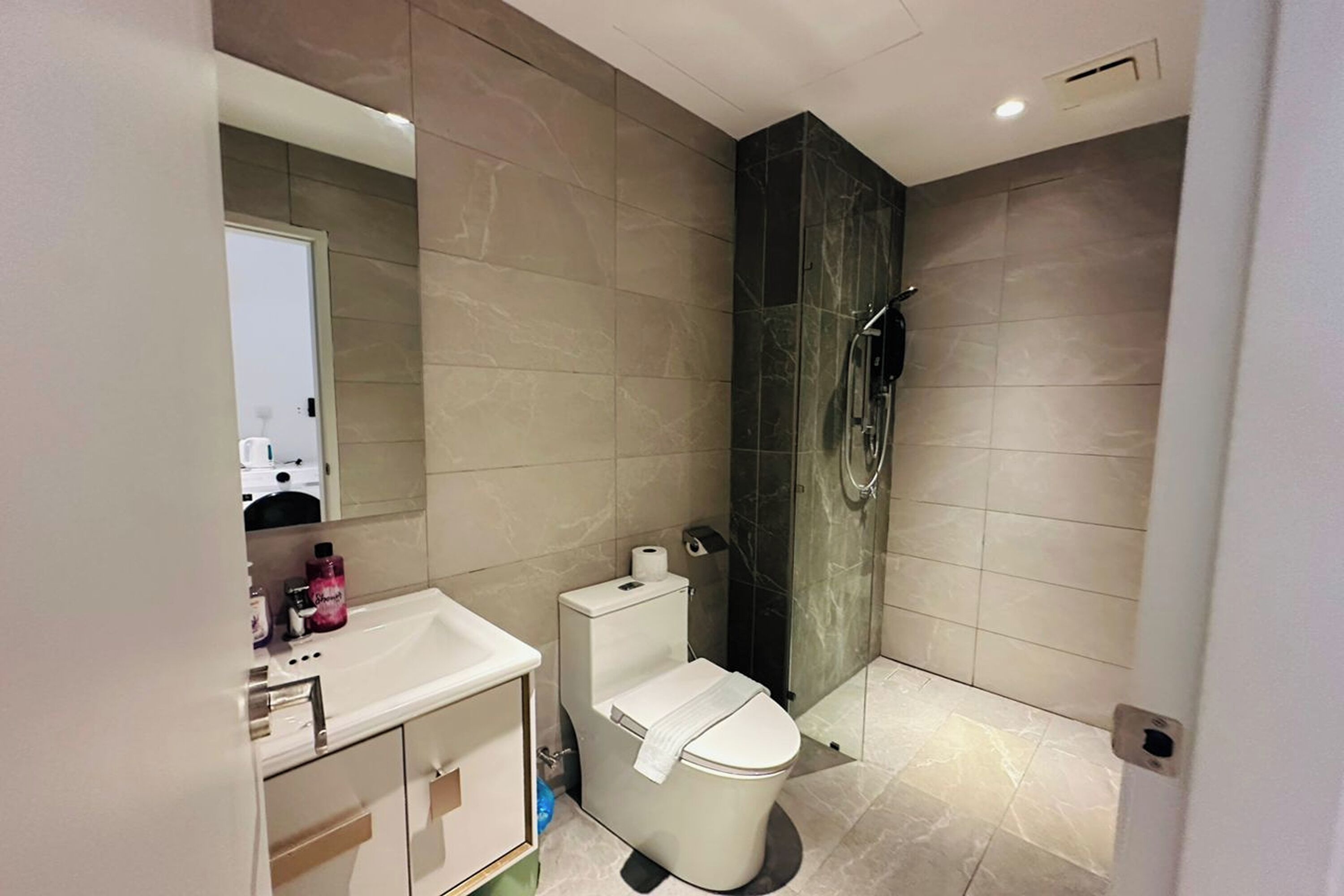 A modern bathroom with a toilet, sink, and shower.