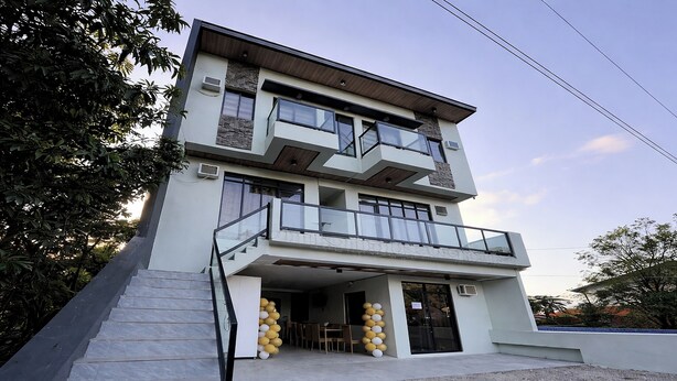 A multi-story building with a balcony, stairs, and a gravel driveway. - Lisro Sleep And Relax La Union near Beach (San Juan)