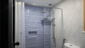 A bathroom with a shower, toilet, and a door with a doorknob. - Lisro Sleep And Relax La Union near Beach (San Juan)