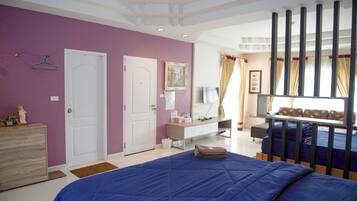 Ein Schlafzimmer mit Bett, Kommode, Schreibtisch und einem Fenster mit Vorhängen.