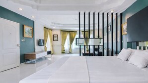 Ein modernes Hotelzimmer mit einem großen Bett, einem Schreibtisch, einem Fernseher und Blick auf den Flur.