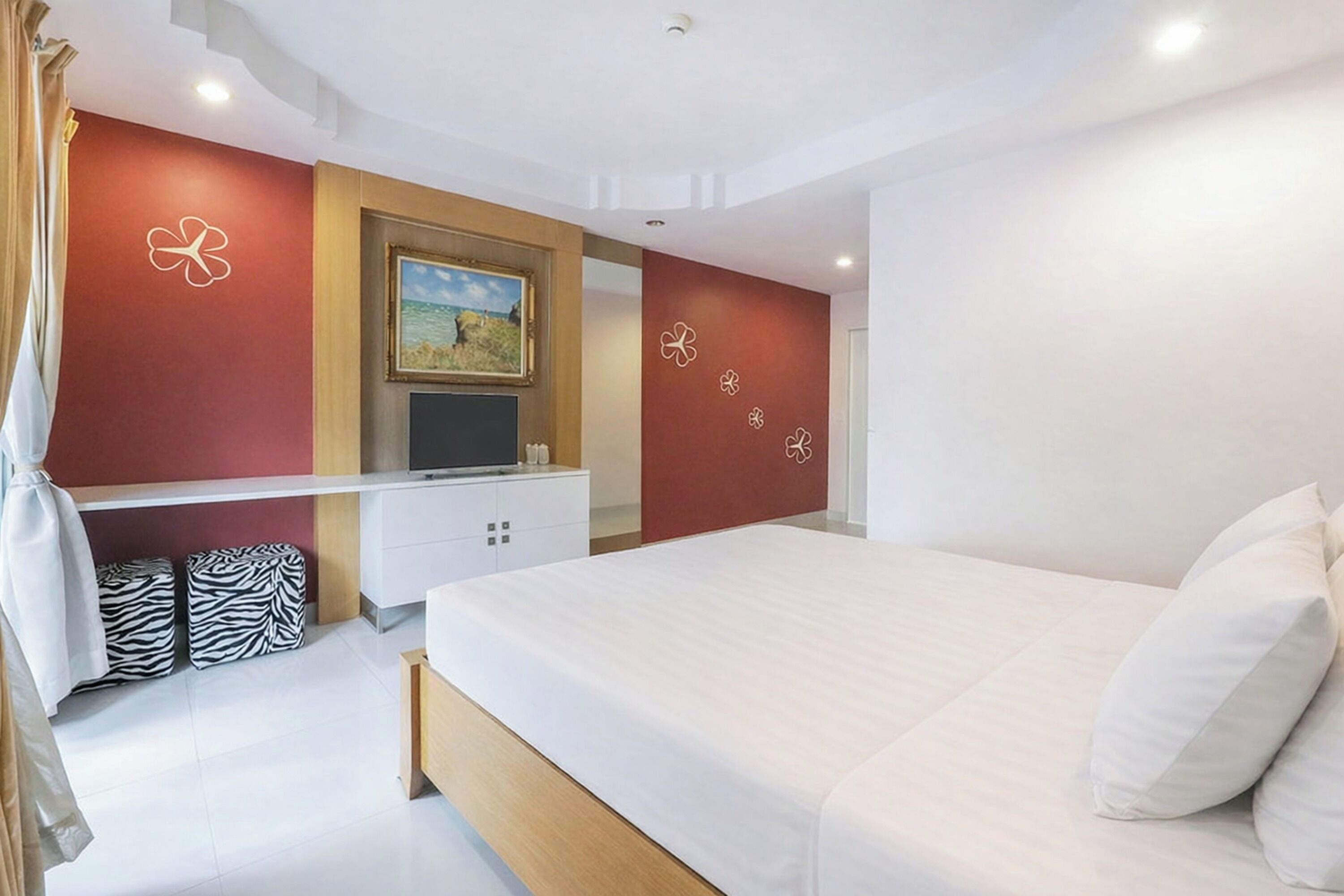 Un dormitorio moderno con cama, televisor y un cuadro en la pared.