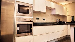 A modern kitchen with built-in appliances, including a microwave, oven, and a coffee maker. - The Mews by Stay Series (Lagos)