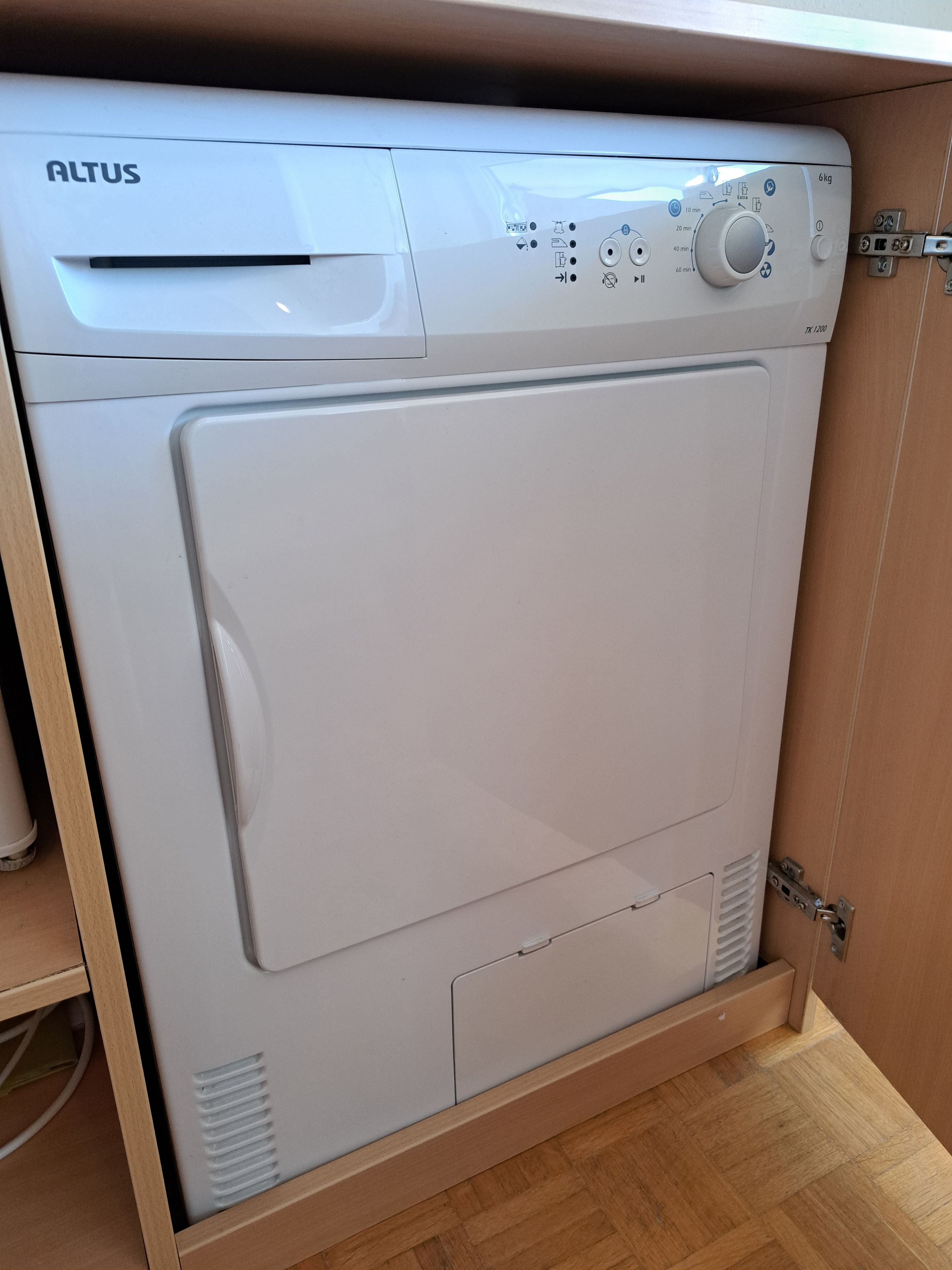 A white Altus washing machine with a control panel, a 6 kg capacity label, and a TK1200 model number.