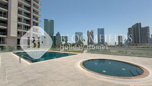 A residential building with a rooftop pool area, including a circular hot tub and a rectangular swimming pool. - Bloomfileds Executive Studio Al MA (Abu Dhabi)