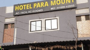 Un bâtiment portant une enseigne indiquant « Hôtel Para Mount » et précisant qu’il propose des chambres avec ou sans climatisation.