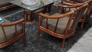 Comedor con una mesa de vidrio rodeada por cuatro sillas de madera con asientos acolchados.