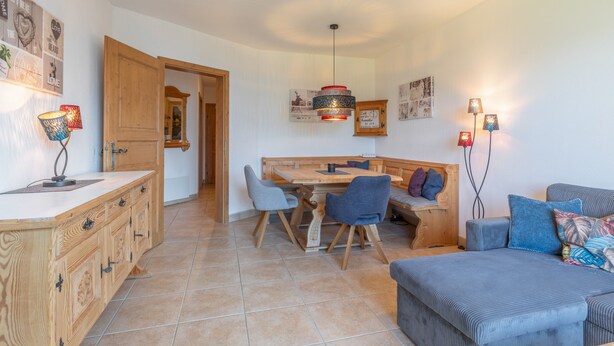 A cozy interior with a wooden dining table, chairs, a bench, and a sofa. - Apartment 'Schladming Planai Mitte' with Mountain View, Private Terrace and Wi-Fi (Schladming)