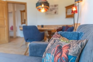 A living room with a sofa, a chair, and a table. - Apartment 'Schladming Planai Mitte' with Mountain View, Private Terrace and Wi-Fi (Schladming)