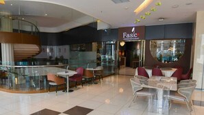 Un ristorante cinese moderno con facciata in vetro, posti a sedere interni e una scala che conduce a un piano superiore.