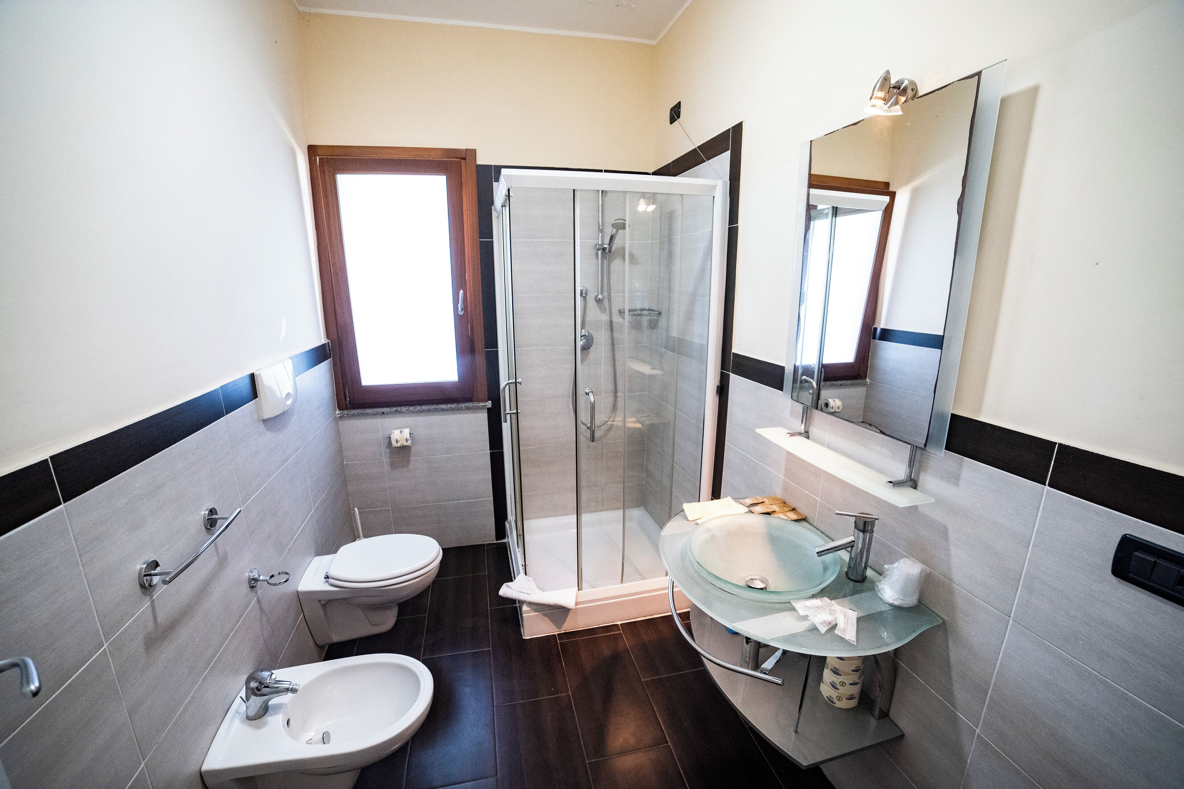 Un baño con cabina de ducha de vidrio, inodoro, lavabo y espejo.