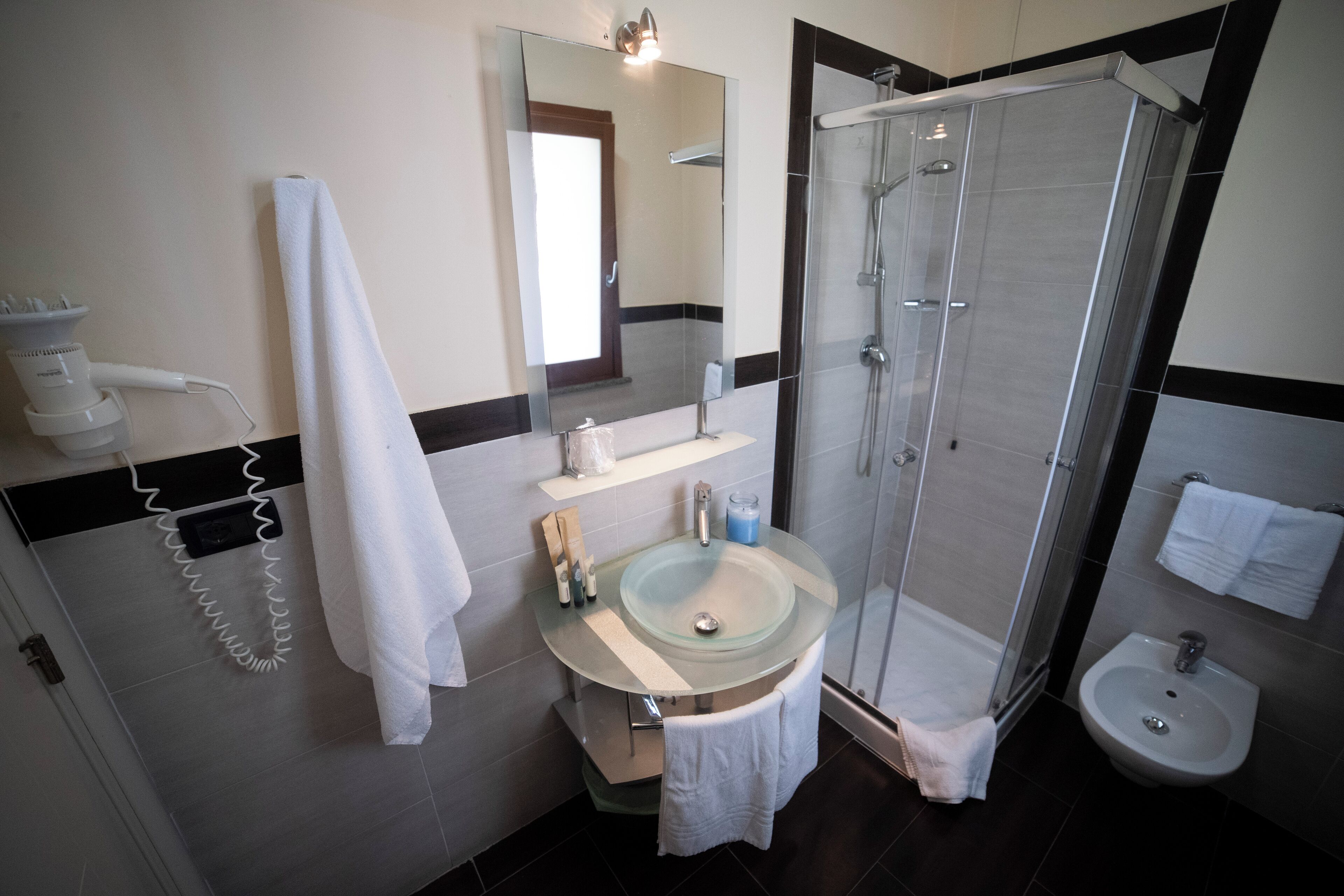 Uma casa de banho moderna com chuveiro envidraçado, lavatório e bidé.