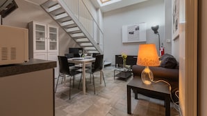 A modern living room with a dining area, a staircase, and skylights. - Loft Stampa by Wonderful Italy (Turin)