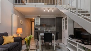 A modern apartment with a living room, dining area, kitchen, and a staircase. - Loft Stampa by Wonderful Italy (Turin)