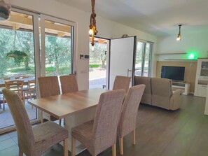 A modern living room with a dining area, a sofa, a TV, and a fireplace. - In einem spektakulären Olivenhain in einer ruhig by Interhome (Bardolino)