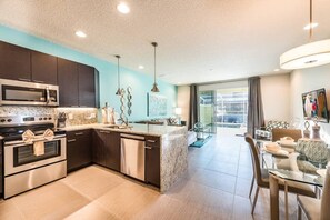 A modern kitchen with dark cabinets, stainless steel appliances, and a central island. - Super cozy home with private pool (Four Corners)