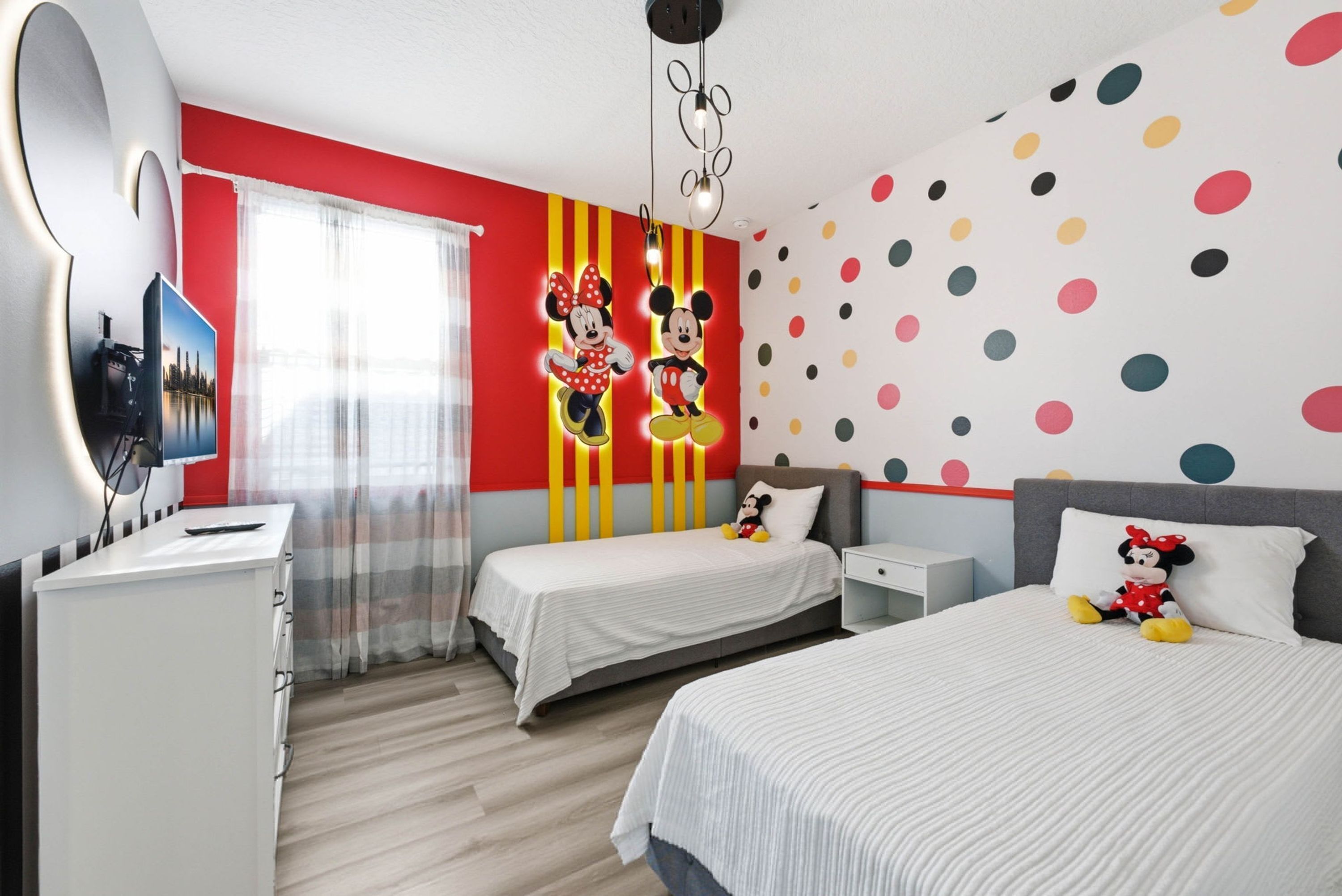 Ein Hotelzimmer mit Bett, Schreibtisch und Fernseher.