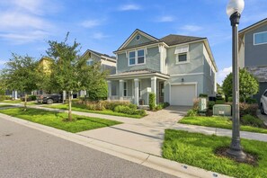 A residential street with houses, a sidewalk, and a street lamp. - Stunning 7BR Retreat, Private Pool, Perfect Location! (Four Corners)