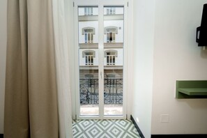 A room with a window, a patterned floor, a green shelf, and a curtain. - La Dimora del Corso 35 (Naples)
